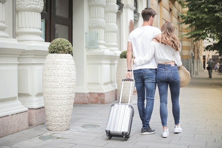 ideal guest 2 - couple with luggage walking along the street